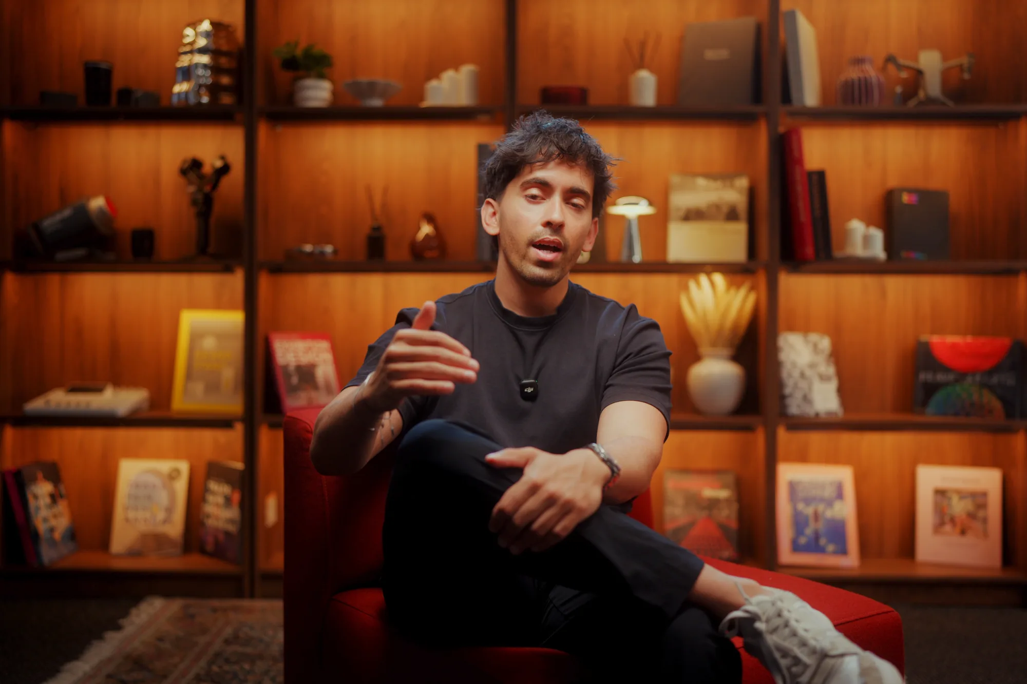 The Founder Talk set: a red armchair in front of warm-lit timber shelves
